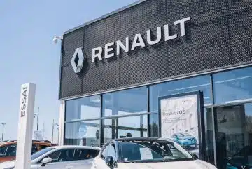 a white car is parked in front of a dealership