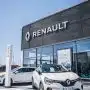 a white car is parked in front of a dealership