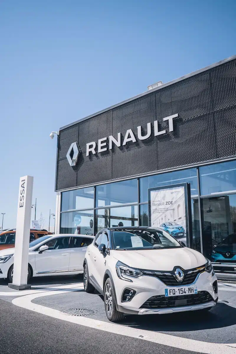 a white car is parked in front of a dealership