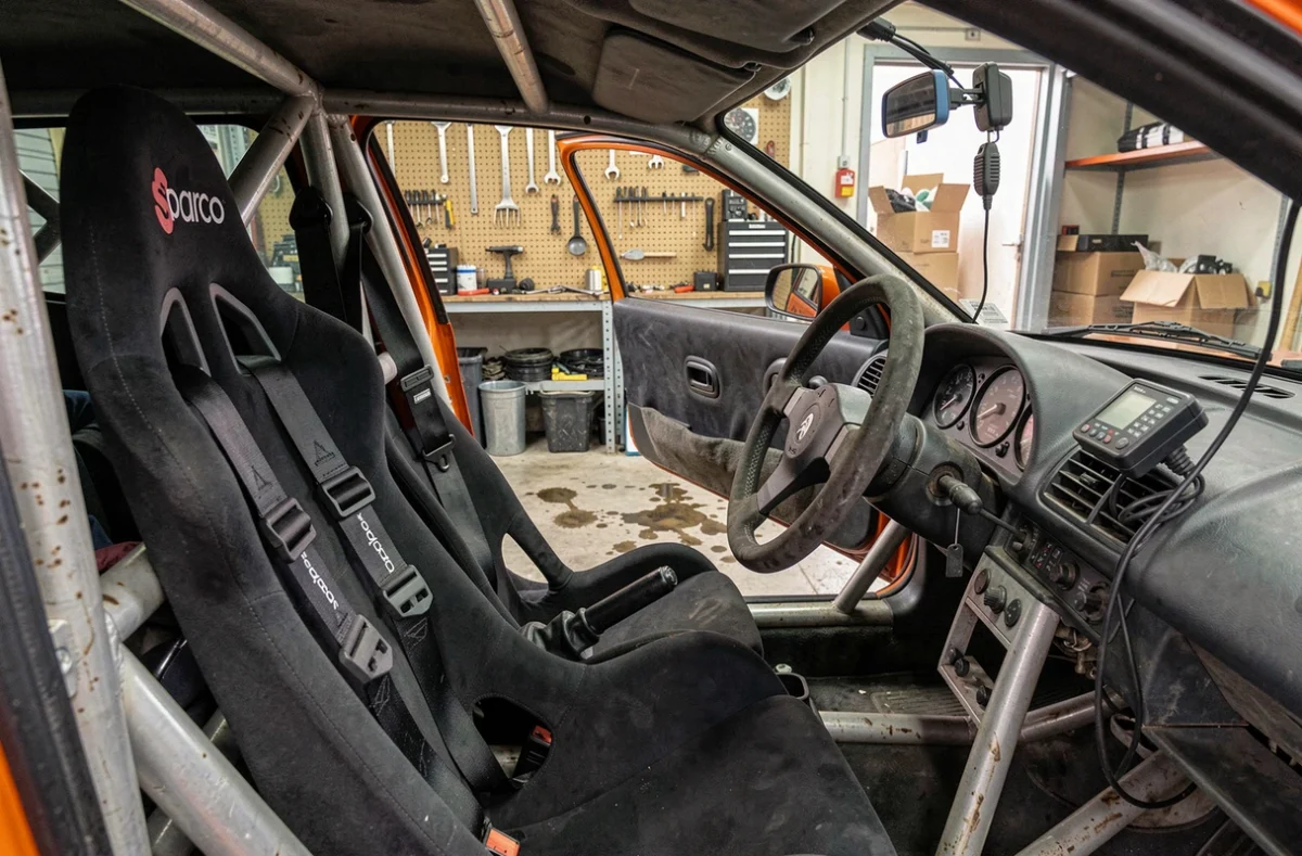 Habitacle d'une Peugeot 106 Maxi équipée pour le rallye avec arceau, harnais et volant sport