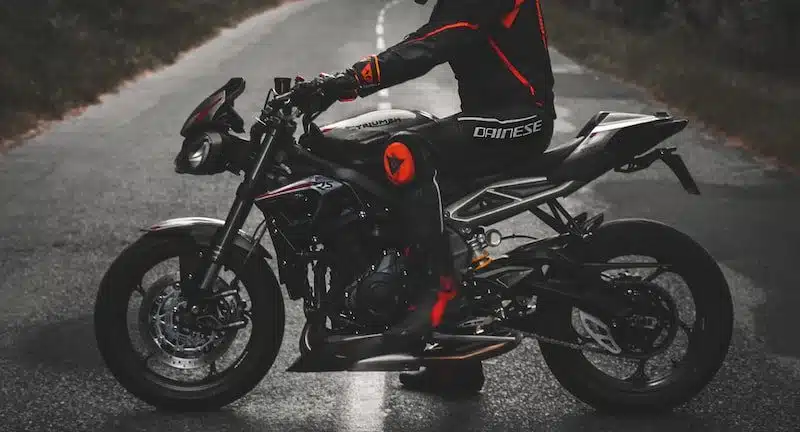 man in white and red jacket riding black sports bike on road during daytime